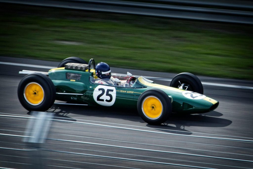 Un coche de Fórmula 1 vintage de color verde con el número 25 circula a toda velocidad por una pista de carreras, mostrando la herencia de las carreras clásicas.