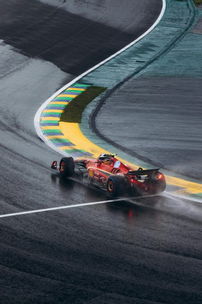 Un coche de Fórmula 1 de Ferrari circula por una curva mojada en el circuito de Interlagos, en Brasil.